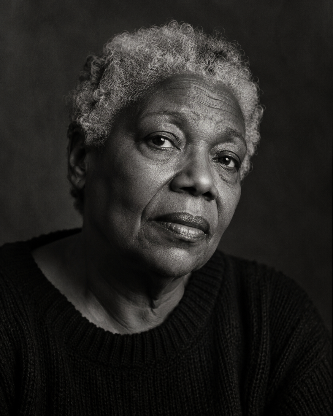 Directed black-and-white portrait of a woman with silver hair in soft window light, headshots Kansas City