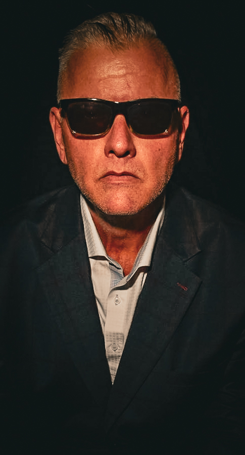 Direct portrait in warm tungsten light, the subject looking straight into the lens