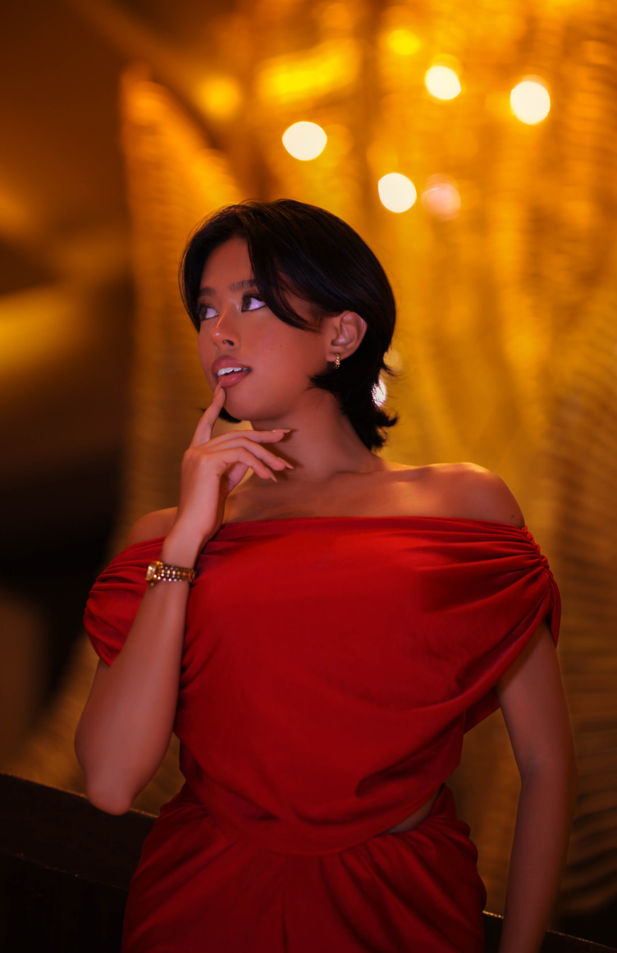 Portrait in a red off-shoulder gown against warm gold bokeh, photographed in Kansas City